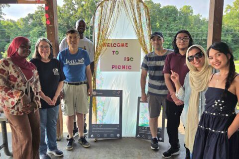 Participants pose around a welcome display during the International Student Council Summer Picnic 2026 held at the Sycamore pavilion in Evergreen Park.
